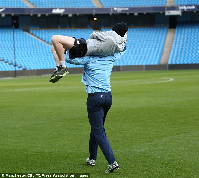 Kompany dengan santai memanggul Ashton keliling lapangan (c) mcfc