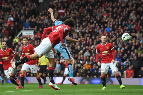 Sundulan Fellaini usai menerima umpan dari Young