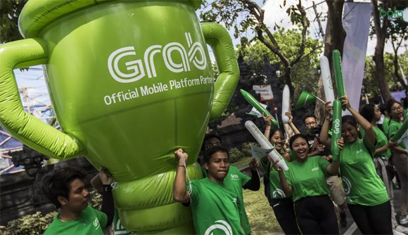 Sejumlah mitra Grab membawa balon raksasa saat pawai obor Asian Games 2018 di Denpasar, Bali.