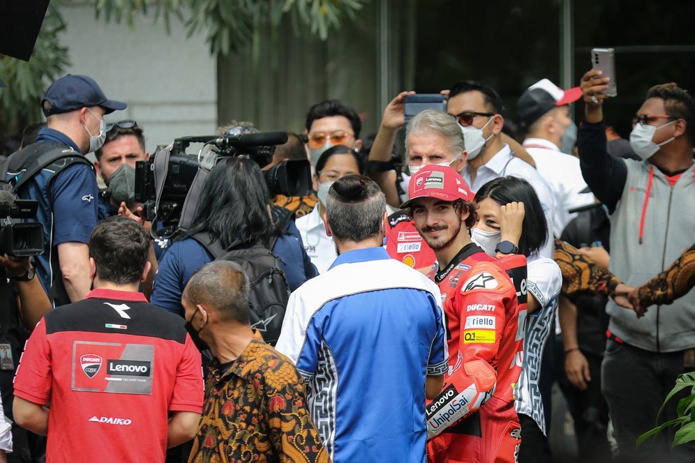 Pecco Bagnaia tersenyum kepada fans usai menonton parade motor di Jakarta jelang balapan di Mandalika, Rabu (16/3/2022). (c) Nexify/Bagaskara Lazuardi