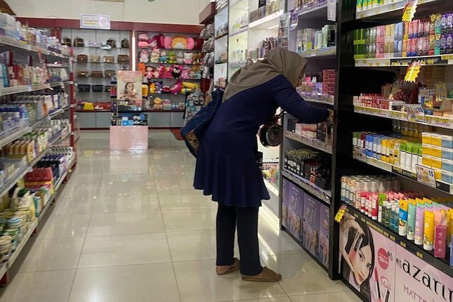Seorang pelanggan sedang memilih produk di Lapak Unique Kosmetik Kota Malang (c) Asad Arifin