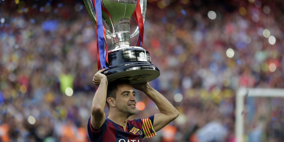 Gelandang Barcelona Xavi Hernandez mengangkat trofi La Liga di Camp Nou setelah Barcelona menjadi juara, 23 Mei 2015. (c) AP Photo