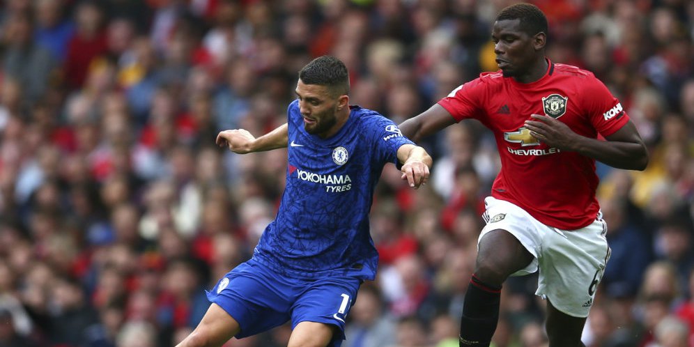 Paul Pogba berusaha merebut bola dari penguasaan Mateo Kovacic di laga Manchester United vs Chelsea di Old Trafford, Minggu (11/08/2019). (c) AP Photo