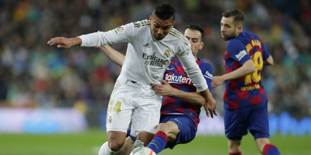 Casemiro berebut bola dengan Sergio Busquets di laga El Clasico antara Real Madrid vs Barcelona di Santiago Bernabeu, Senin (02/03/2020) dini hari WIB. (c) AP Photo
