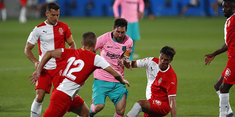 Bintang Barcelona, Lionel Messi (tengah) mencoba melewati hadangan pemain Girona. (c) AP Photo
