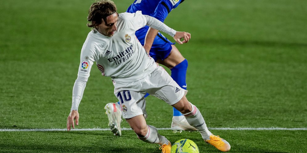 Aksi Luka Modric melawan pemain Getafe, La Liga 2020/21. (c) AP Photo