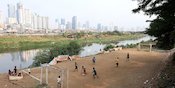 Potret Anak-anak Ibu Kota Bermain Sepak Bola di Pinggir Kali